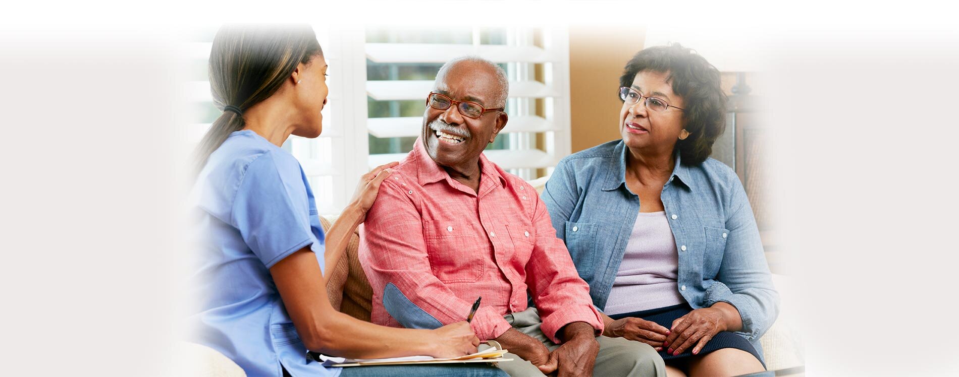 Caregiver helping senior couple.