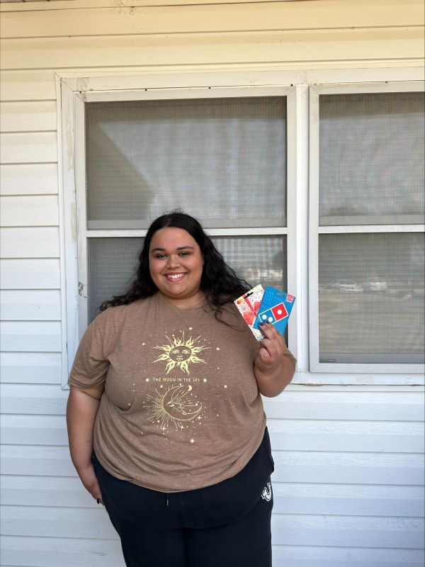 A girl holding two gift cards.