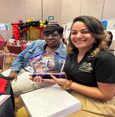 Two woman sitting next to each other smiling for a picture.