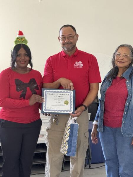 Jimmy Revels smiling and holding his 20 year Service Award.