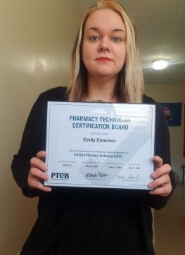 Emily Emerson holding her Pharmacy certificate.