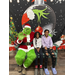 Two children sitting next to the Grinch on a bench. 