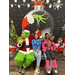 Three young ladies sitting next to the Grinch. 