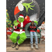 Young man smiling next to the Grinch.