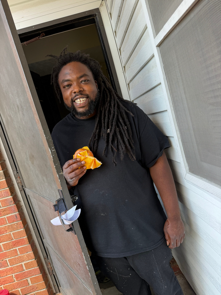 A man smiling and holding a doughnut.